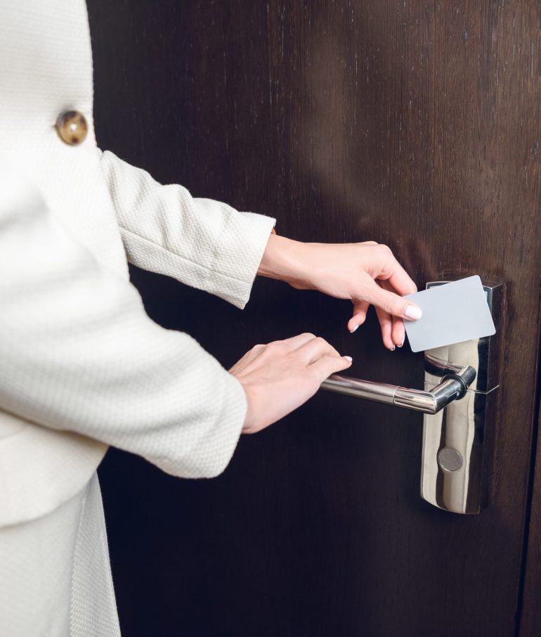 close-up partial view of businesswoman opening hotel room door