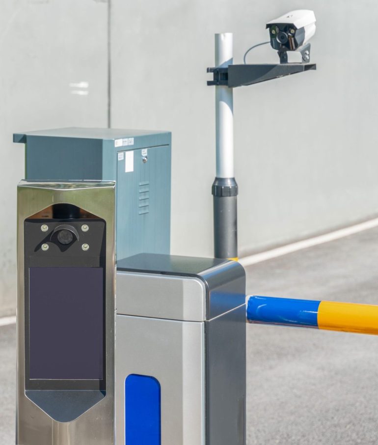 A closeup of an automatic parking lot identification system with a barrier arm